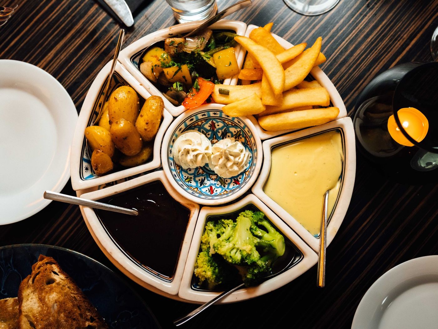 Runde Servierplatte mit Kartoffeln, gegrilltem Gemüse, Pommes frites und Saucen